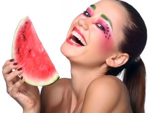 Beautiful young woman eating watermelon