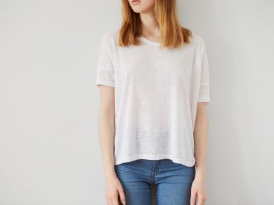 Young girl wearing blank wthite t-shirt. Wall background.