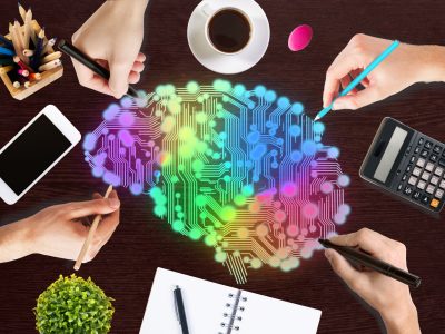 Creative thinking concept with hands drawing abstract colorful digital human brain on wooden office desktop with blank smartphone, coffee cup, stationery items, calculator and decorative plant