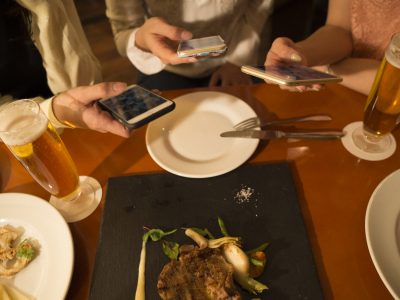 Three women have seen the smartphone during a meal