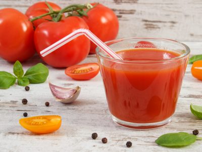 Glass of fresh tomato juice and vegetables with spices on old rustic wooden background, healthy nutrition