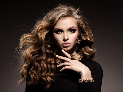 Beautiful woman with long curly hair and gold jewelry