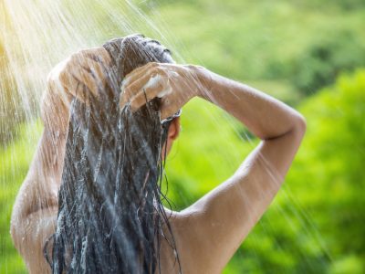 Woman showering and shampooing outdoor